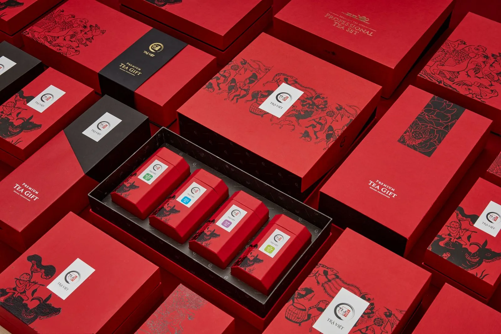 Coffrets cadeaux de thé rouges, l'un ouvert sur quatre petites boîtes de thés différents