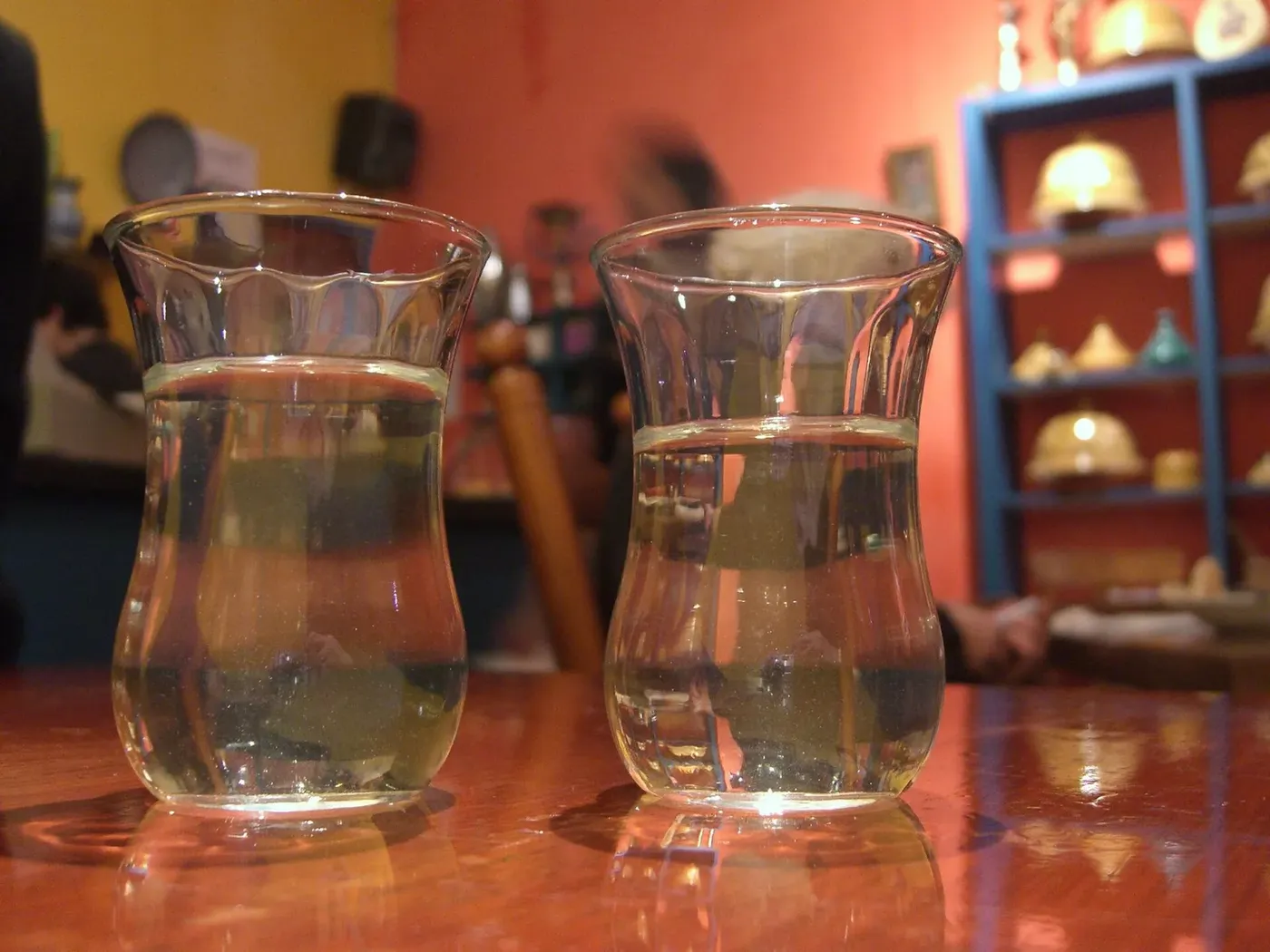 Deux verres à thé marocains posés sur une table en bois