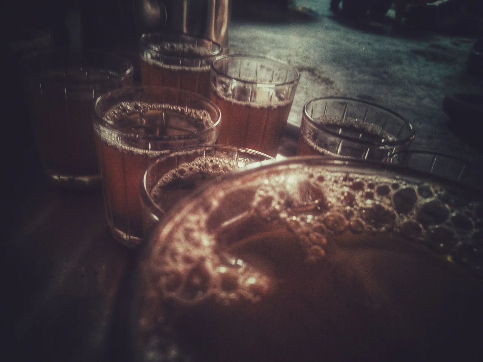 Verres à thé marocain remplis, coiffés de mousse, autour d'un plateau