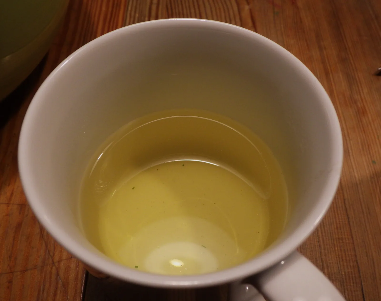 Tasse de tisane de verveine citronnelle infusée en vrac, posée sur une table en bois
